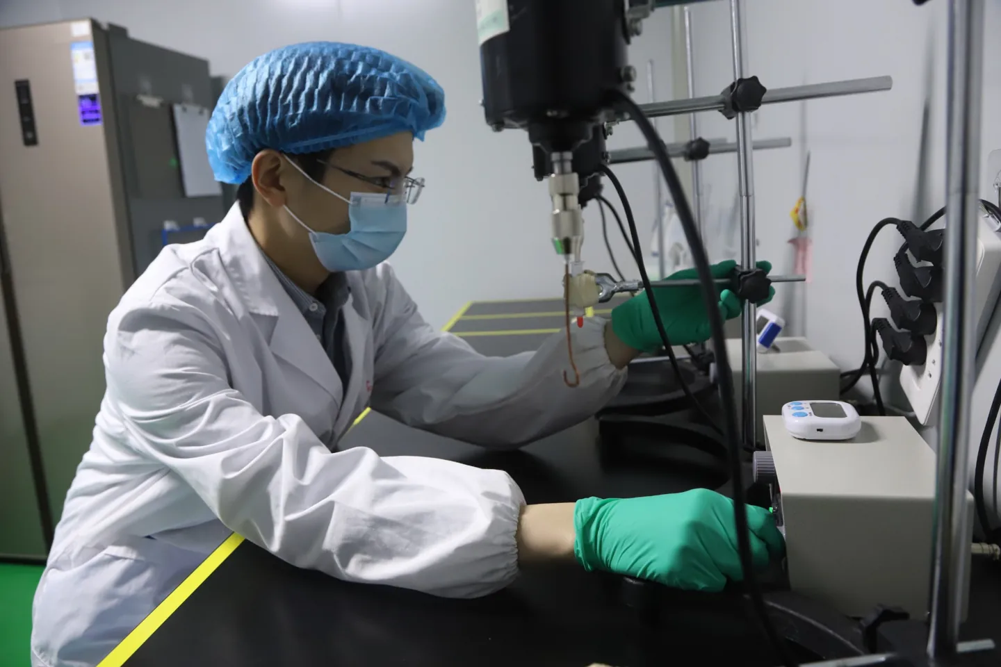Laboratory technician operating an electric stirring device during antigen emulsification