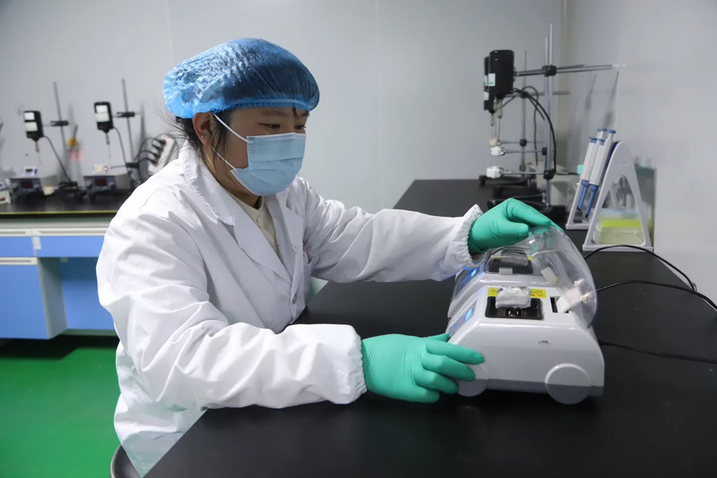 Laboratory technician using a shaker device for emulsion preparation